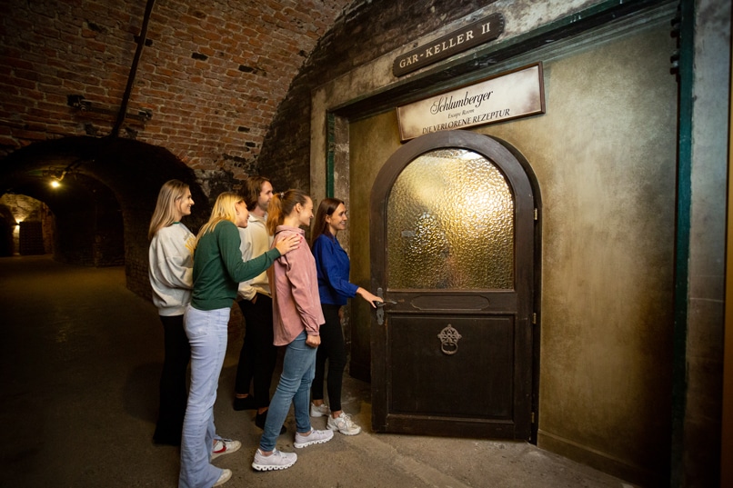 Fünf Personen betreten den analogen Escape Room "Die verlorene Rezeptur" im Keller der Weinkelterei Schlumberger in Wien